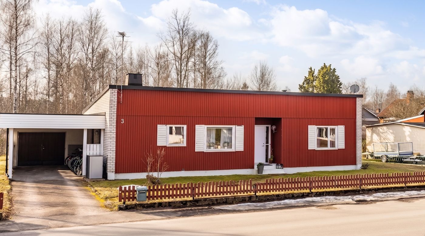 Das rote Holzhaus in der Mellangatan 3 in Emmaboda mit Carport und rotem Lattenzaun